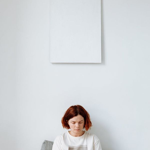 A calm and focused individual during an online guided session on a laptop.