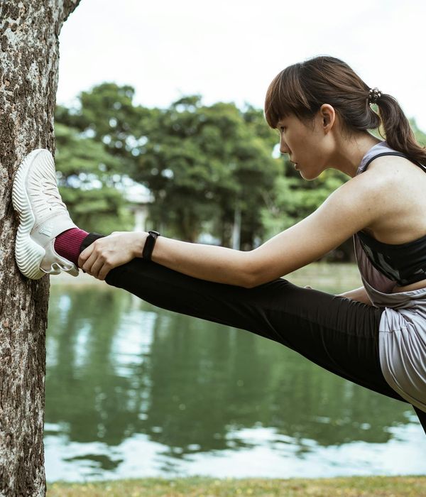 Woman in comfortable activewear practicing mindful walking in a serene park setting.